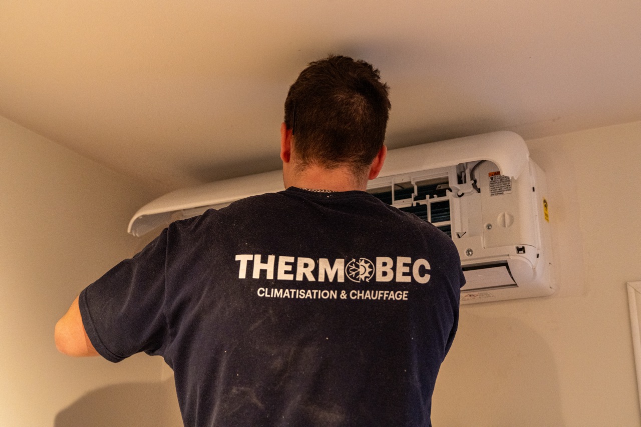 Un homme qui installe un climatiseur